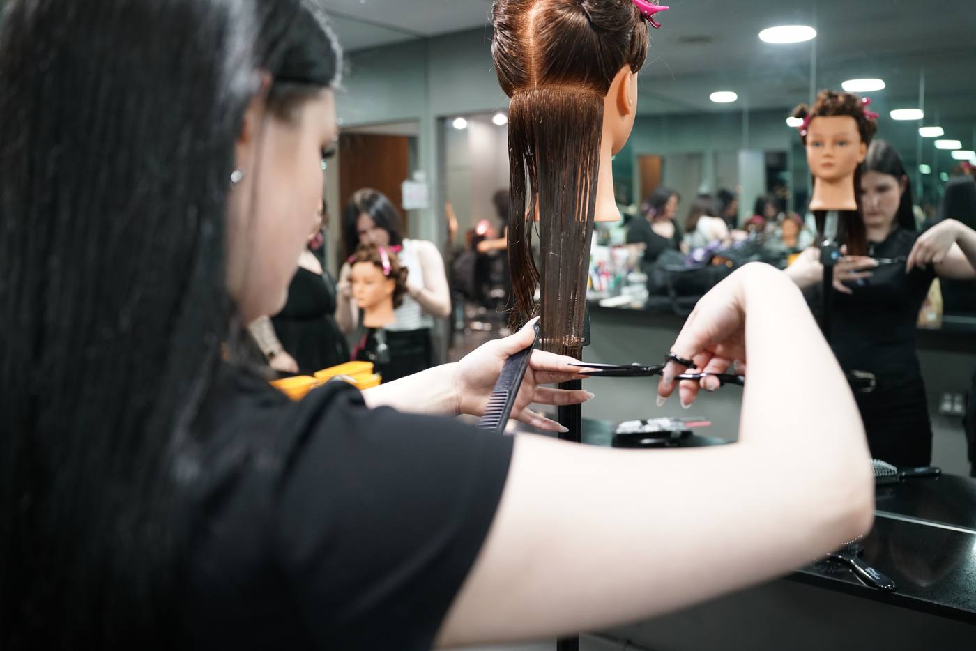 Student cutting hair on first day at Aveda Institute Vancouver hair school BC